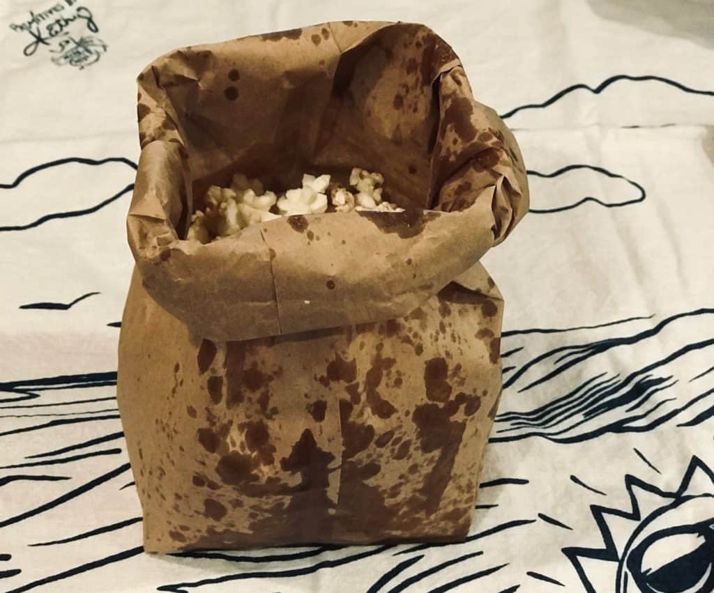 Microwave Popcorn In Paper Bag finished product sitting up on towel with paper bag top folded over ready to serve