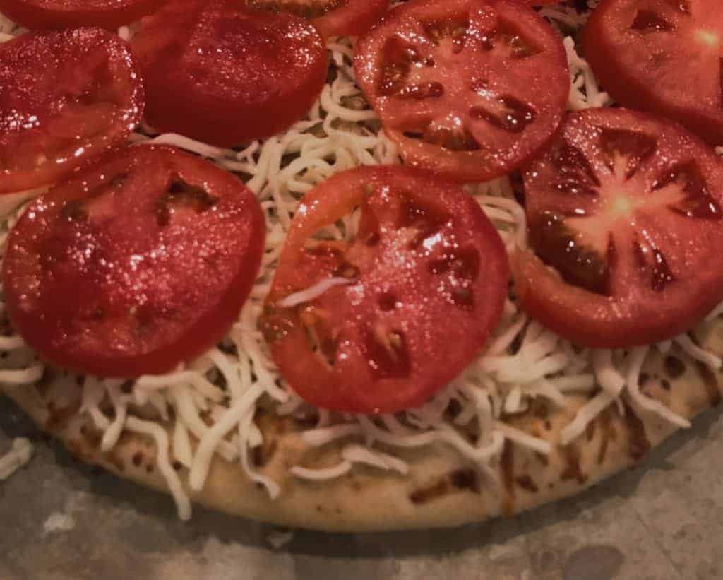 Pizza crust with cheese and tomatoes