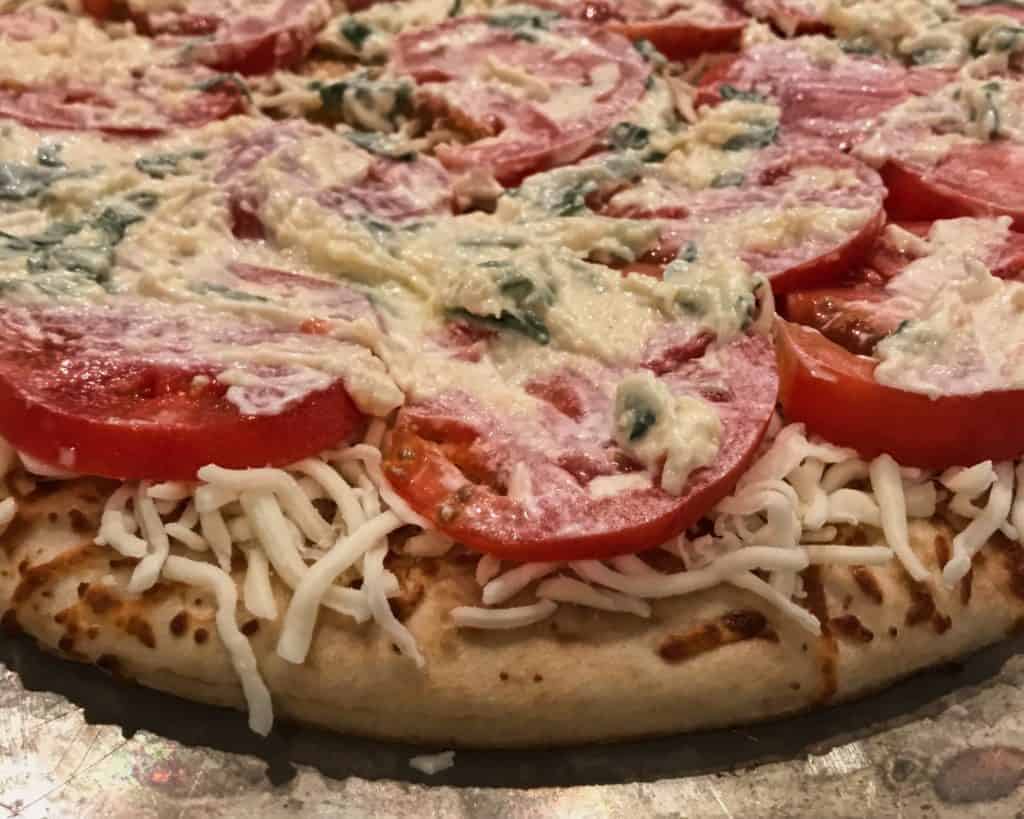 Pizza with white sauce before baking